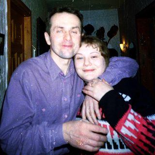 A man and child hugging indoors.