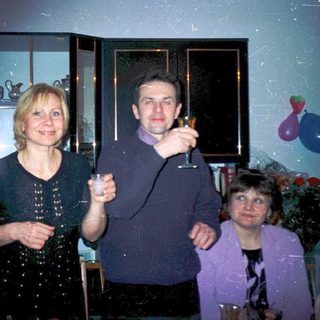 Three people celebrating indoors with champagne glasses.