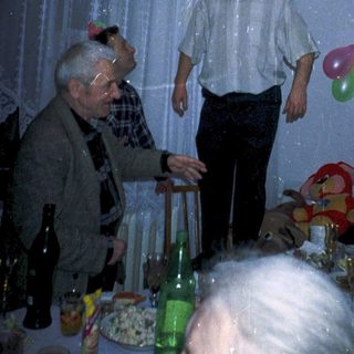 Celebratory birthday party with older guests indoors.