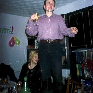 Man celebrating with champagne indoors.