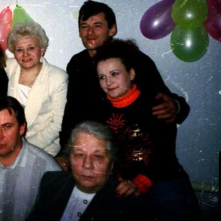 Family celebrating 45th birthday with balloons.