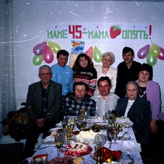 Family celebrating 45th birthday with balloons and cake.