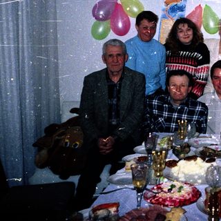 Family celebrating 45th birthday with balloons and cake.