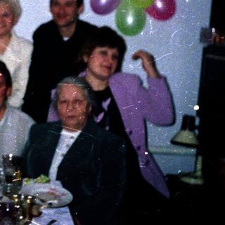 Family celebrating 45th birthday indoors with balloons.
