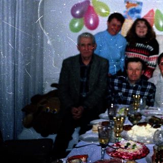Family celebrating 45th birthday indoors with balloons.