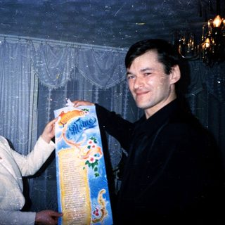 Two people holding and opening a gift-wrapped package.