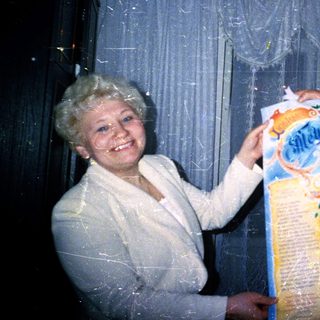Two people holding and opening a gift-wrapped package.