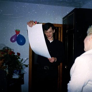 Man holding large rolled banner indoors with woman.