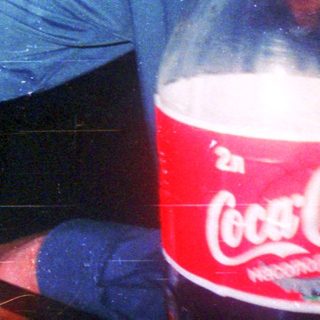 Man smoking while drinking near Coca-Cola bottle.
