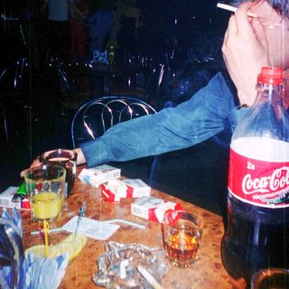 Person appears exhausted at table with drinks and snacks.