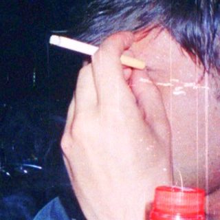 Person appears exhausted at table with drinks and snacks.