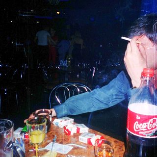Person appears exhausted at table with drinks and snacks.
