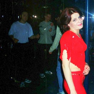 Woman in red outfit performing on pole.