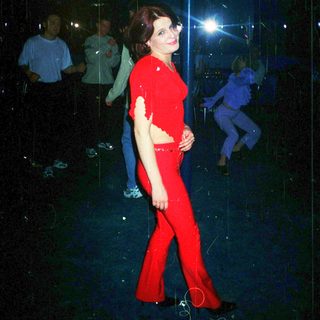 Woman in red outfit performing on pole.