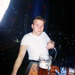Young man pouring beer at dimly lit bar.