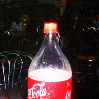Blurry night scene with Coca-Cola bottle.