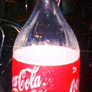 Blurry night scene with Coca-Cola bottle.