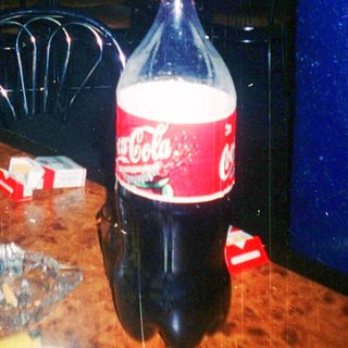 Kitchen scene with Coca-Cola bottle, empty glasses, and scattered items.
