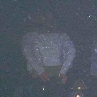 Dark nightclub with illuminated dance floor and stage lights.