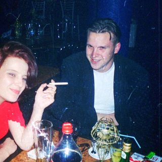 Two people enjoying drinks and conversation indoors.