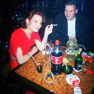 Two people enjoying drinks and conversation indoors.
