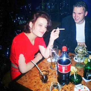 Two people enjoying drinks and conversation indoors.