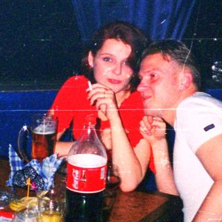 Two people sharing an intimate moment at nightclub bar.