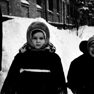 Two children smiling in winter snow.