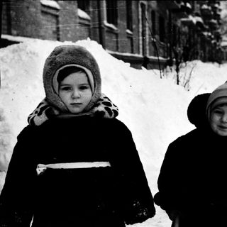 Two children dressed warmly in winter snow.