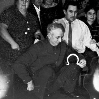 Group of people indoors during mid-20th century gathering.