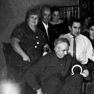 Group of people indoors during mid-20th century gathering.