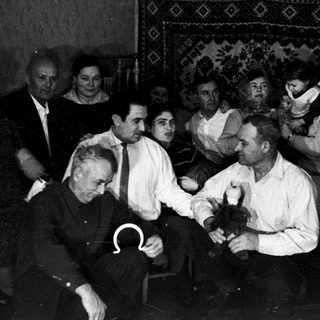 Group of men in a barber shop receiving haircuts.