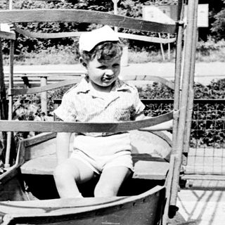Child riding a small spinning amusement ride.