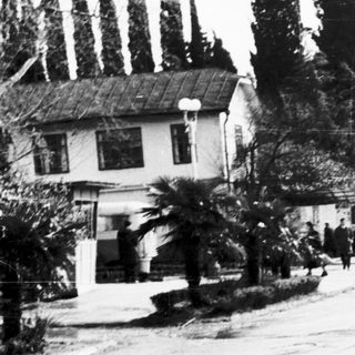 Two uniformed men walking down a quiet residential street.