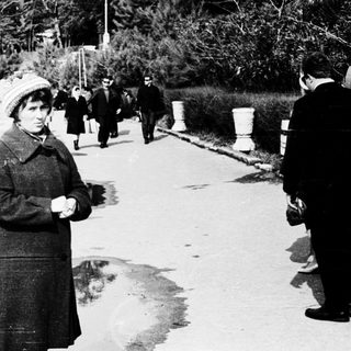 People walking along a coastal path near wartime bunkers.