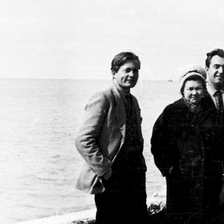 Four people posing by a seaside pier.