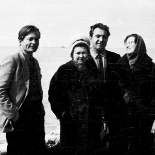 Four people posing by a seaside pier.