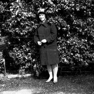 Person in vintage military-style uniform outdoors.
