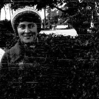 A woman smiling outdoors in winter attire.