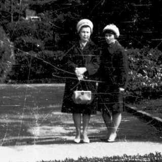 Two women walking together in a park.