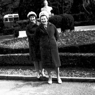 Two women posing together outdoors in vintage clothing.