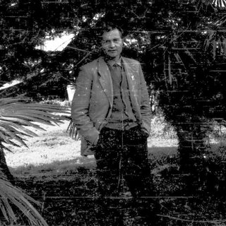 Man standing outdoors in garden setting.