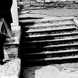 Four people posing on stone steps outdoors.