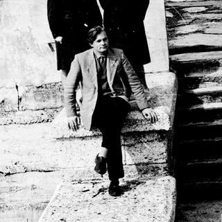 Four people posing on stone steps outdoors.
