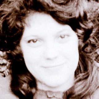 Woman posing outdoors in vintage-style black-and-white photo.