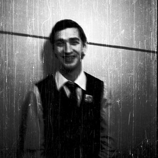 Man smiling in a shower with rain-like water.