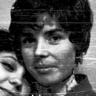 Two people hugging affectionately in a vintage-style photograph.