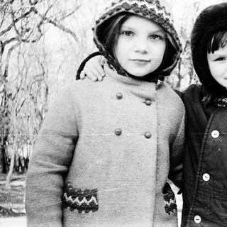 Two children posing outdoors in winter clothing.
