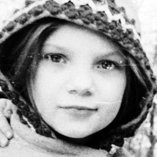 Two children posing outdoors in winter clothing.
