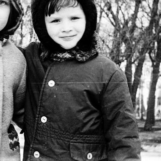 Two children posing outdoors in winter clothing.